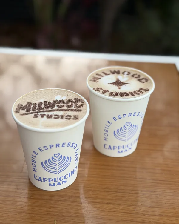 Lattes with the Milwood Studios logo stenciled in cocoa, by Cappuccino Man