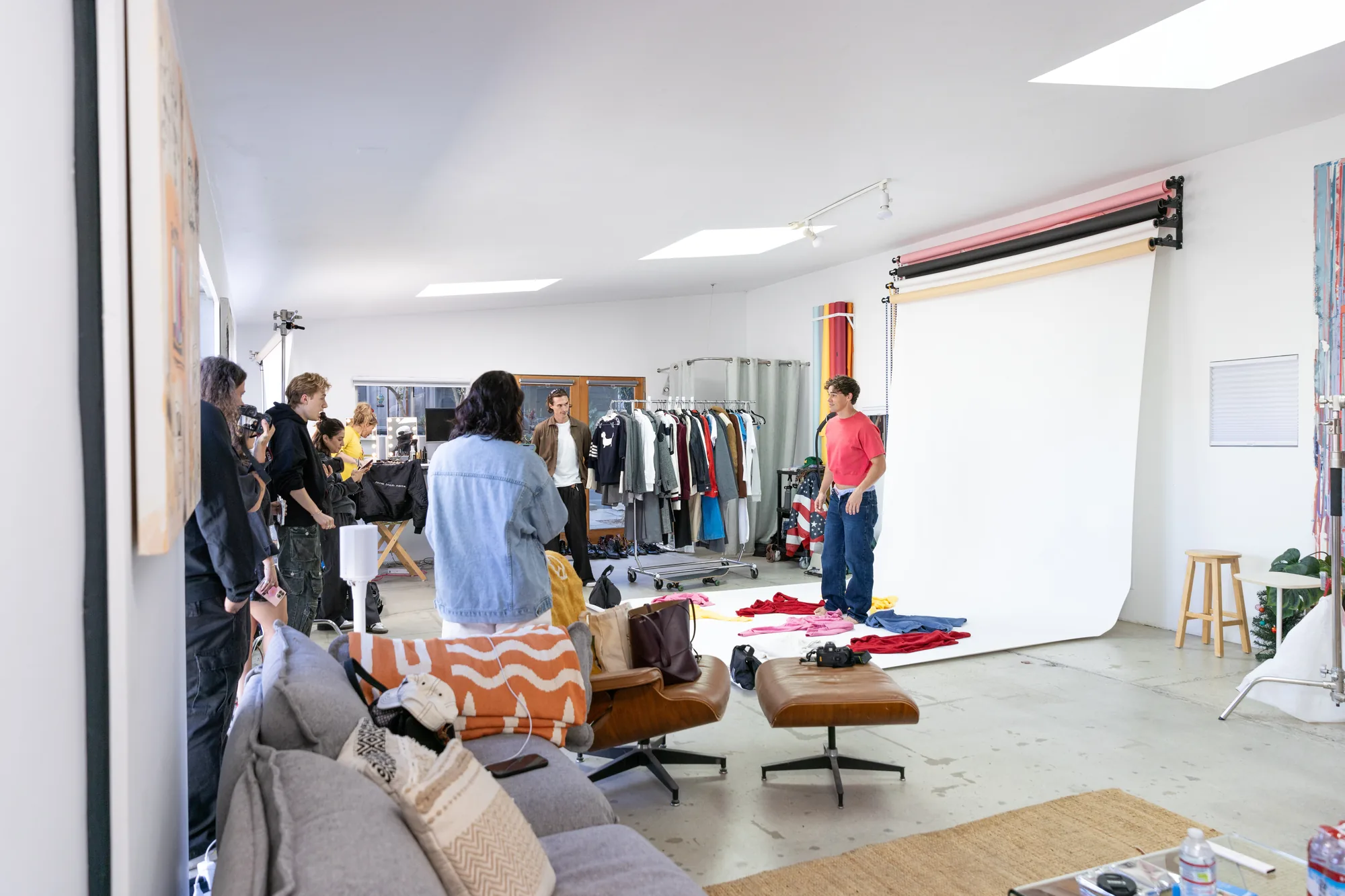 Fashion shoot in progress with wardrobe racks and seamless backdrop at Milwood Studios